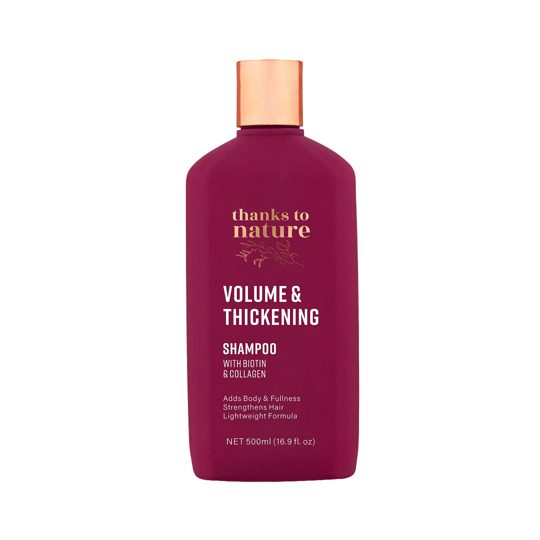 A 500ml bottle of Thanks to Nature Volume & Thickening Shampoo. The bottle is a deep magenta color with a metallic copper cap, featuring white and gold text on the front label.