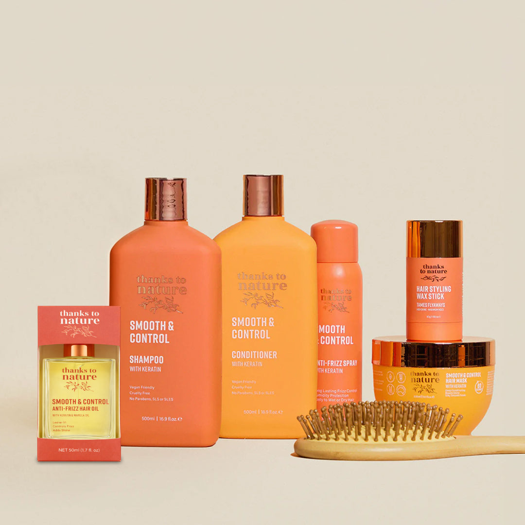 Thanks to Nature Smooth and Control Collection of hair care products including bottles and a brush on a beige background